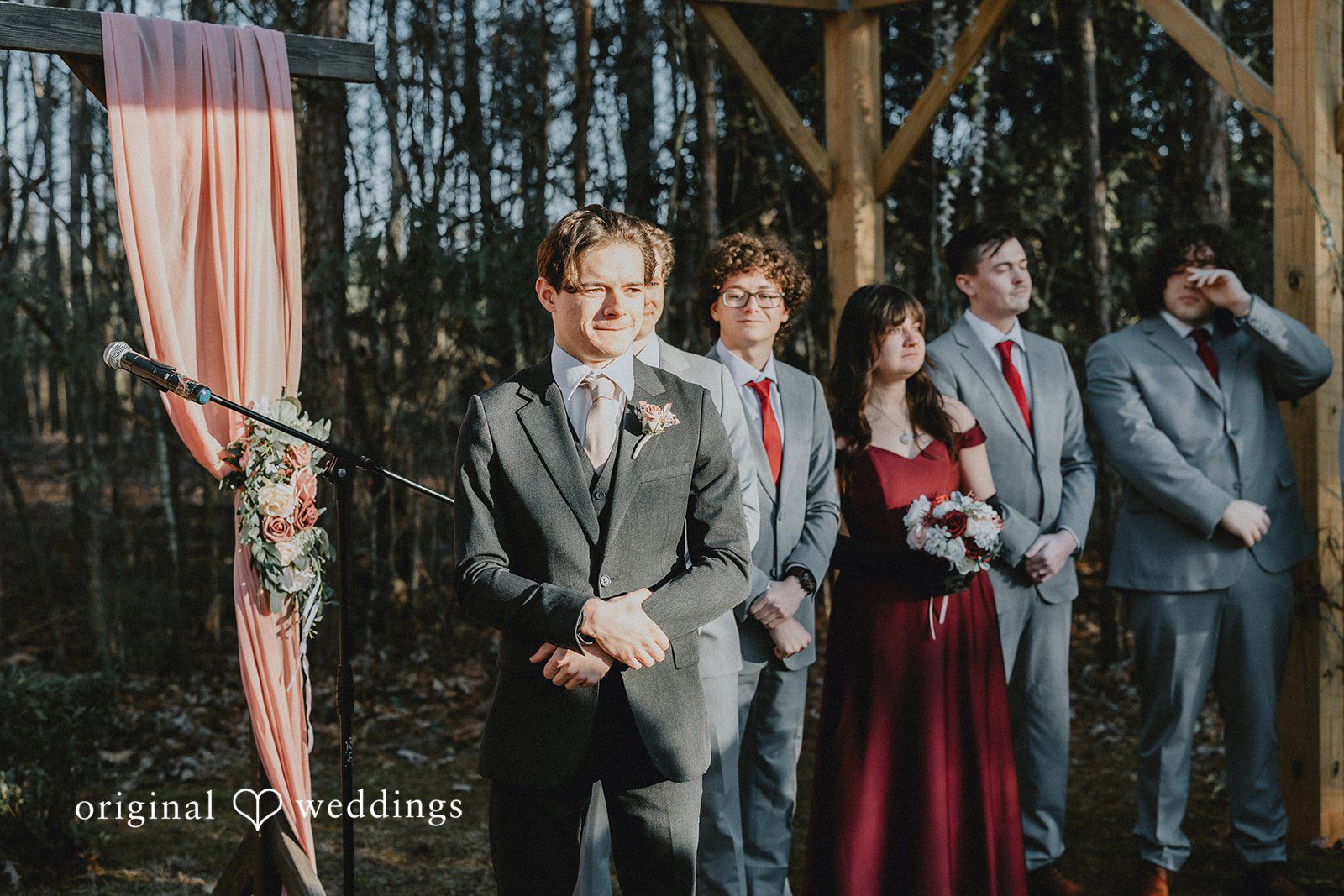 Ayana + Gabriel A groom and his groomsmen standing together by a wooden fence.