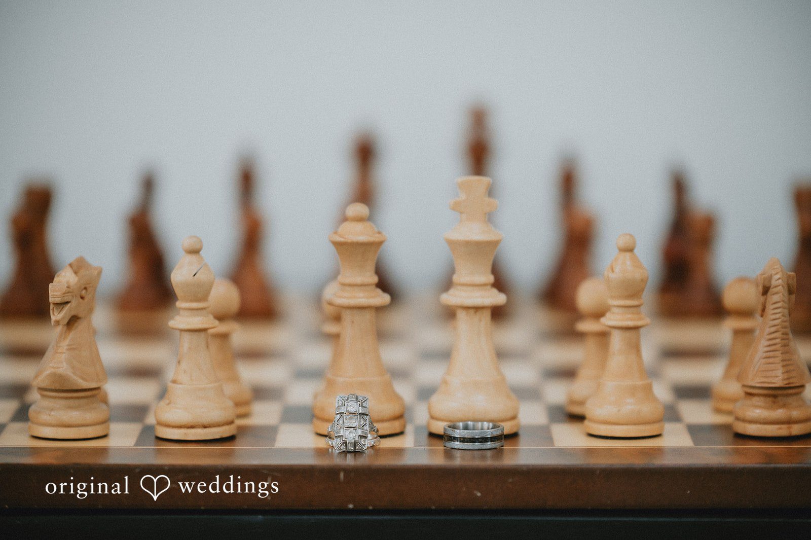 Ayana + Gabriel A wooden chess set arranged on a board for Ayana and Gabriel's wedding.