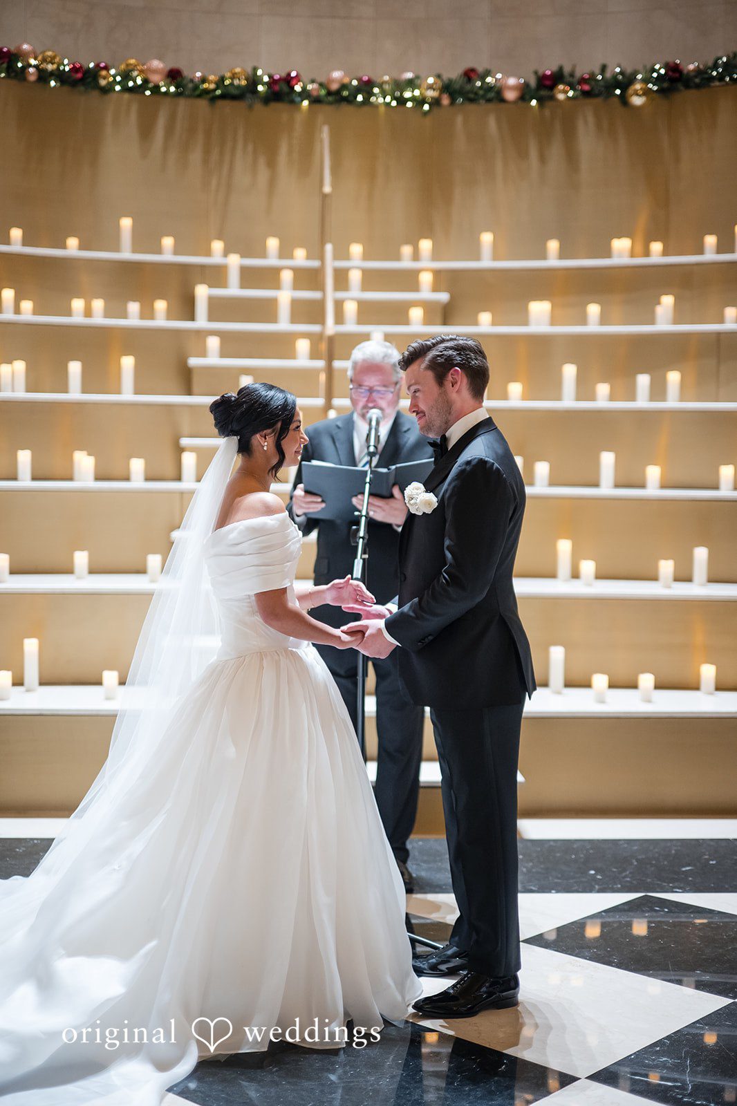 A bride and groom standing together at the altar holding hands during their wedding ceremony.