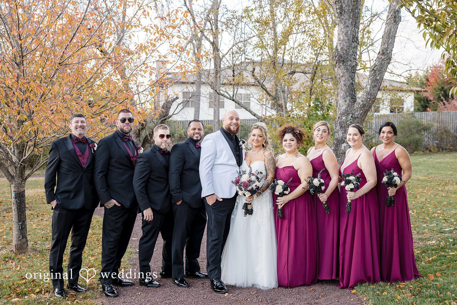 April + Joseph Bride and groom posing with bridesmaids and groomsmen outdoors