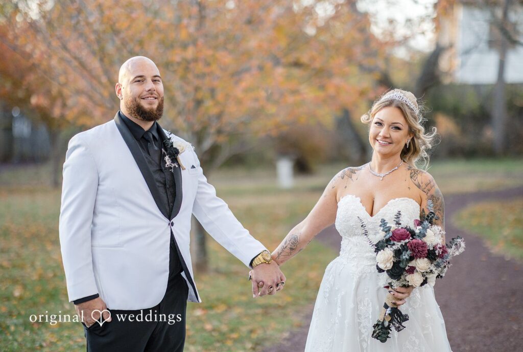 April + Joseph Newlywed couple holding hands during outdoor wedding session at Lochwood Manor captured by Philadelphia wedding photographers from Original Weddings
