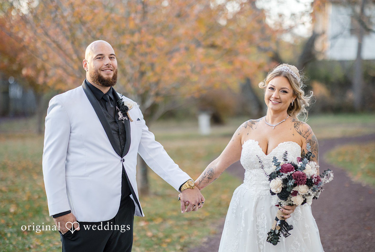 Newlywed couple holding hands during outdoor wedding session at Lochwood Manor captured by Philadelphia wedding photographers from Original Weddings