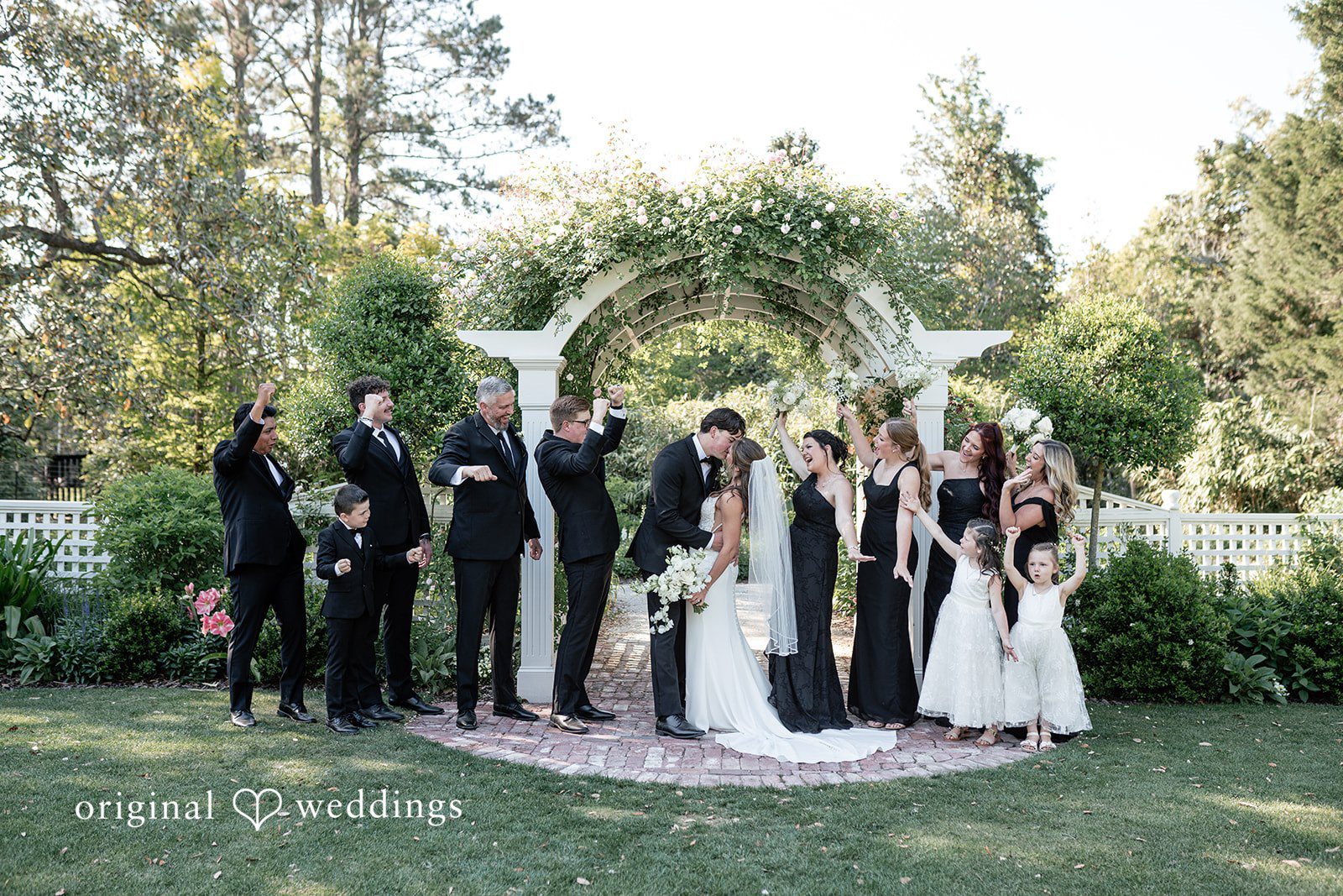 A romantic portrait of the couple with cheers from their bridal party