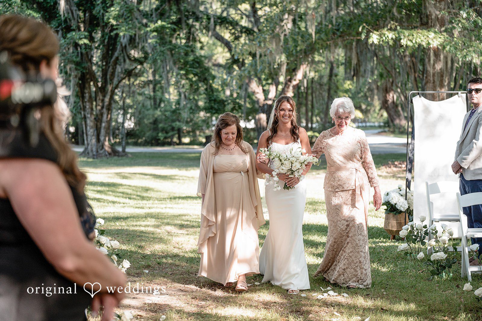 The bride's family escorts the bride down the aisle