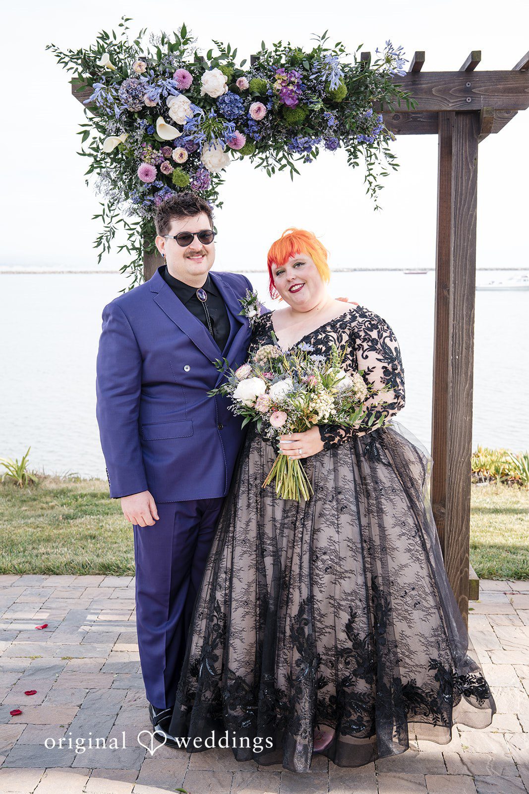 Morgan + Todd Bride and groom posing together with flowers in the background