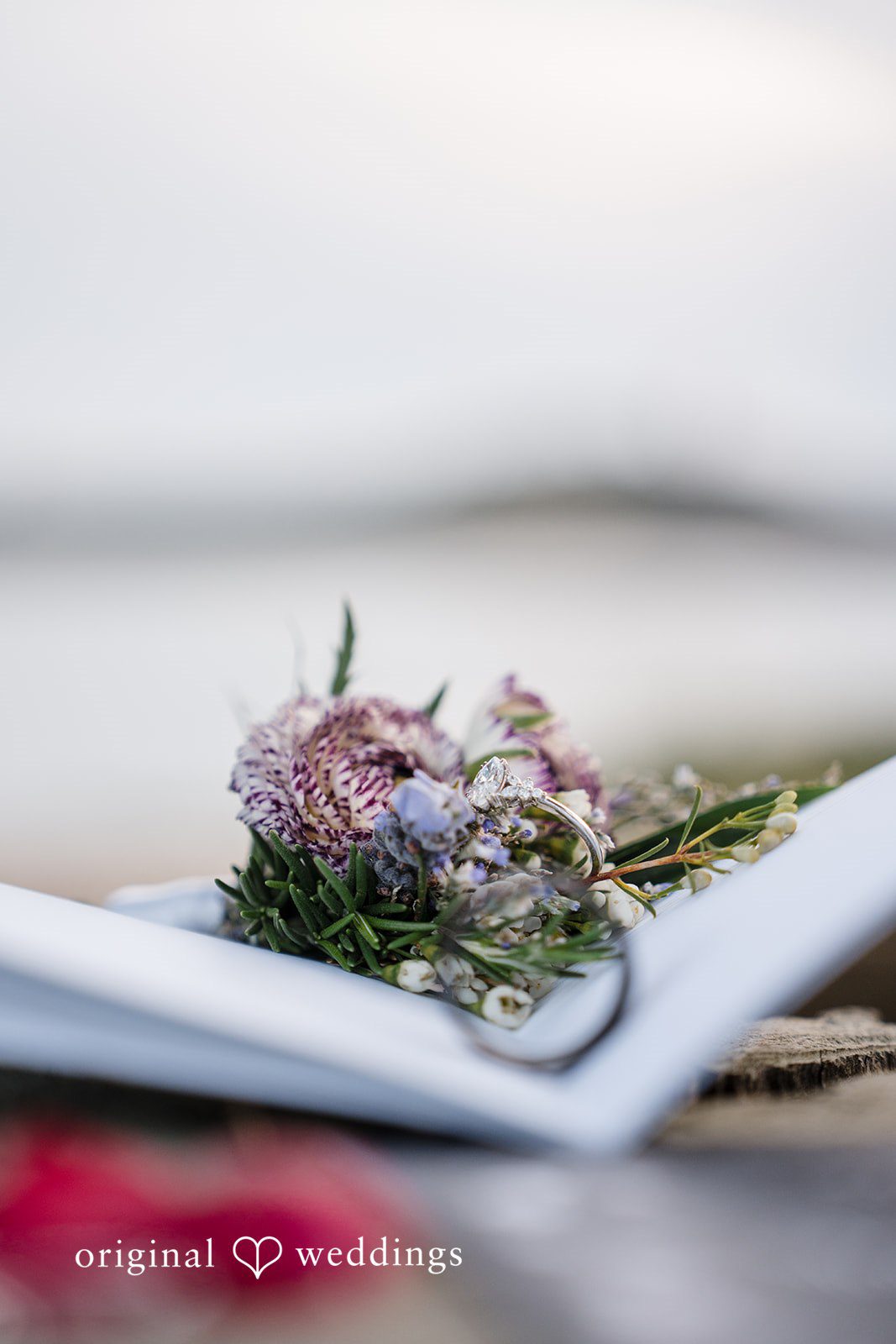 Morgan + Todd Close-up of an engagement ring placed among wedding flowers