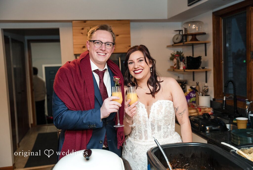 Logan + Bryan Happy newlyweds holding drinks during wedding celebration captured by Detroit wedding photographers from Original Weddings