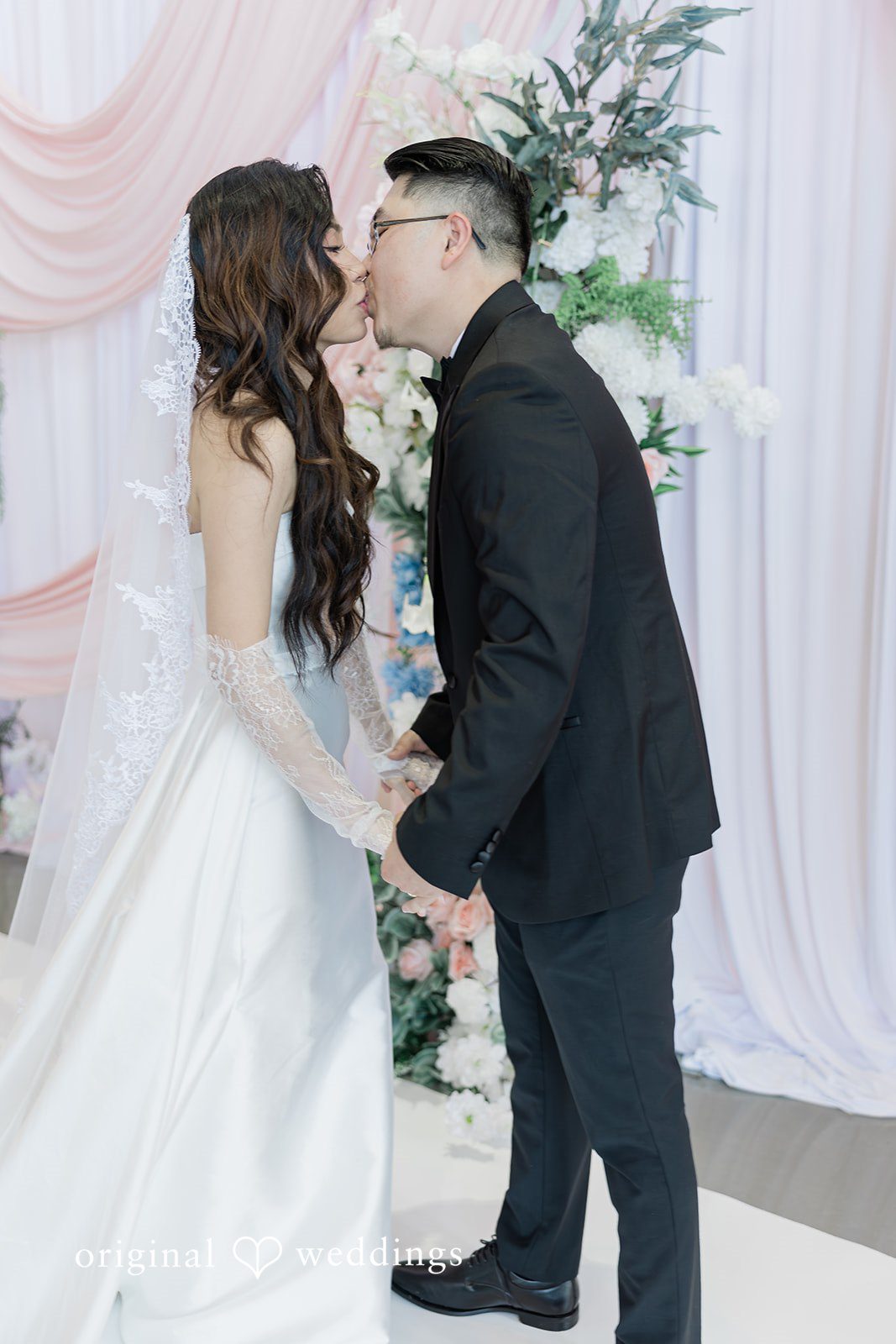 Khanh + Trung Bride and groom sharing their first kiss during wedding portraits