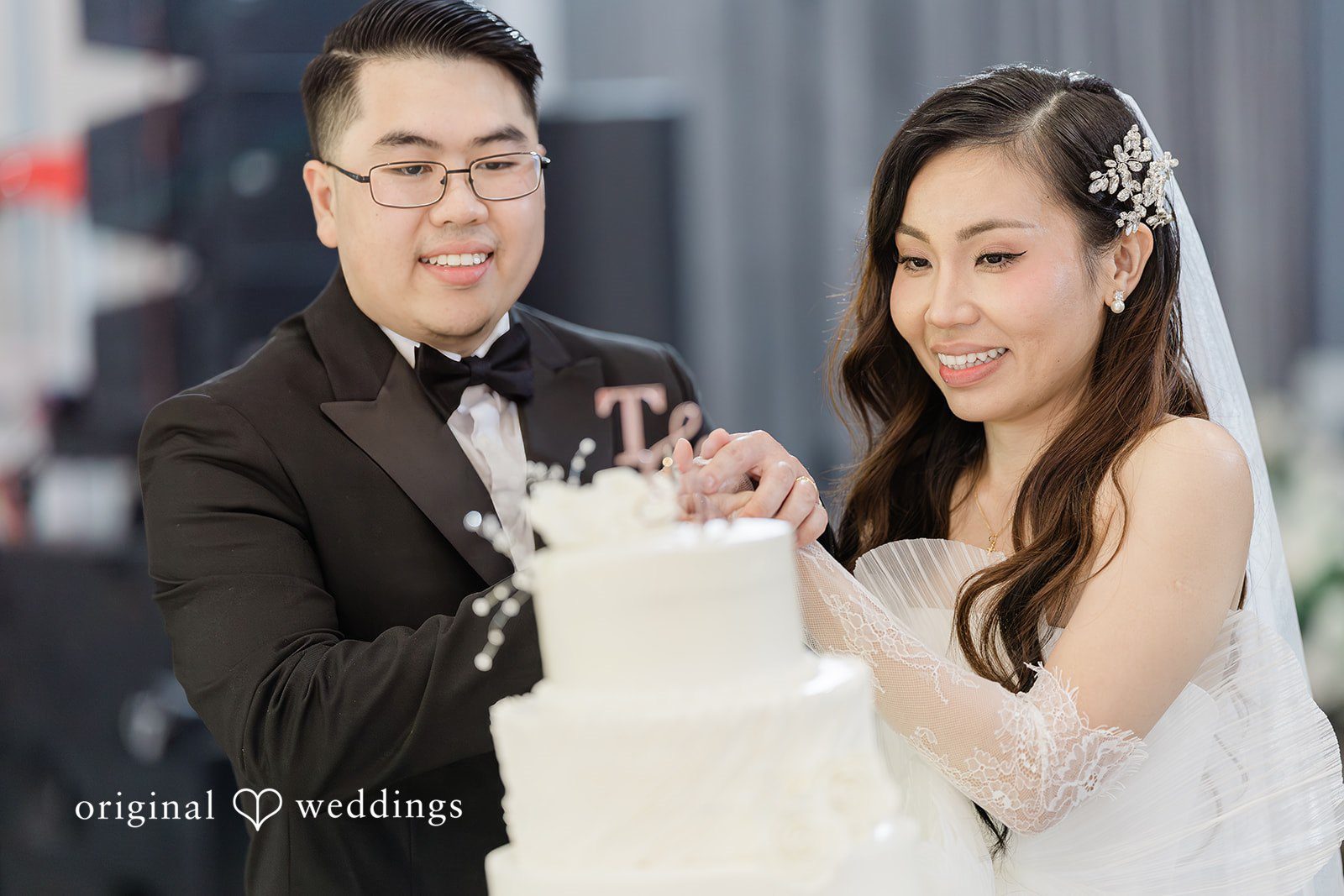Khanh + Trung Bride and groom cutting their wedding cake together