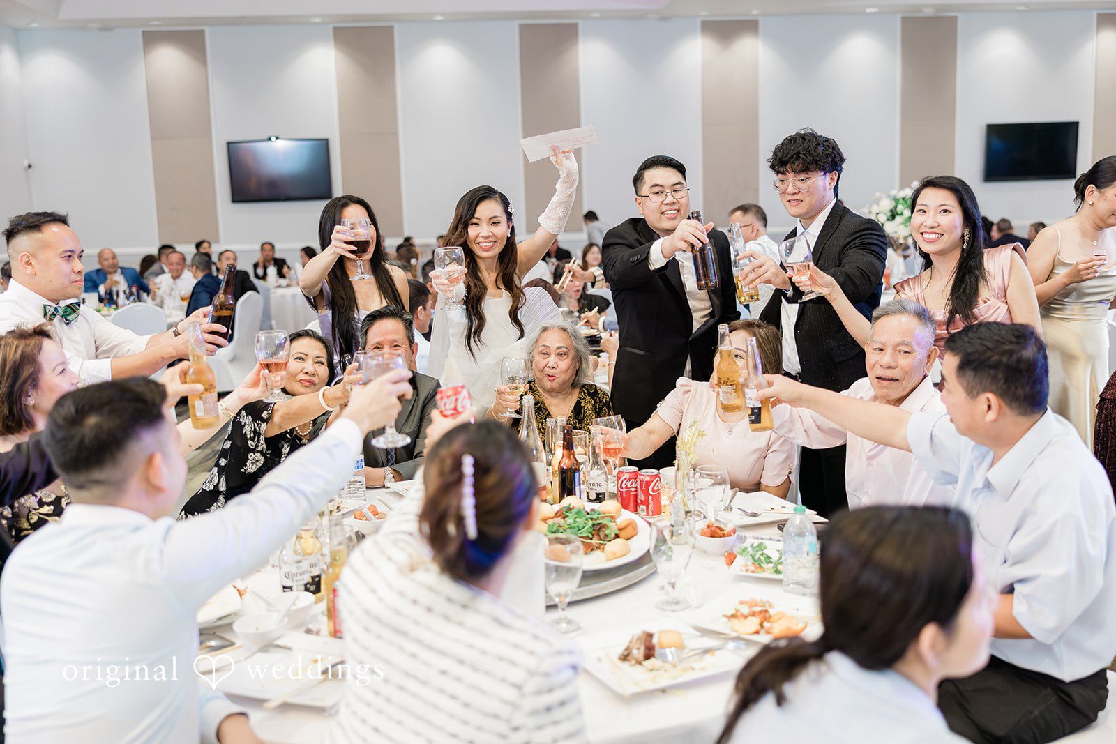 Khanh + Trung Bride and groom dining with guests during the reception