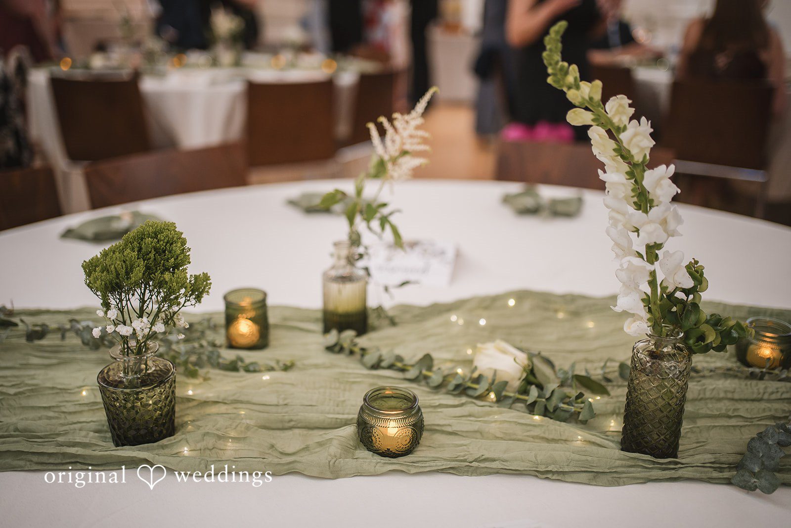 Peyton + Mia Close-up of candle and floral table decor at the reception