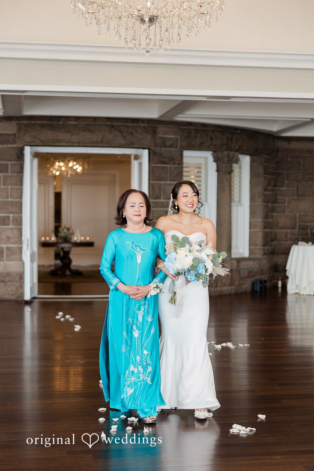 The bride's mother escorts her down the aisle