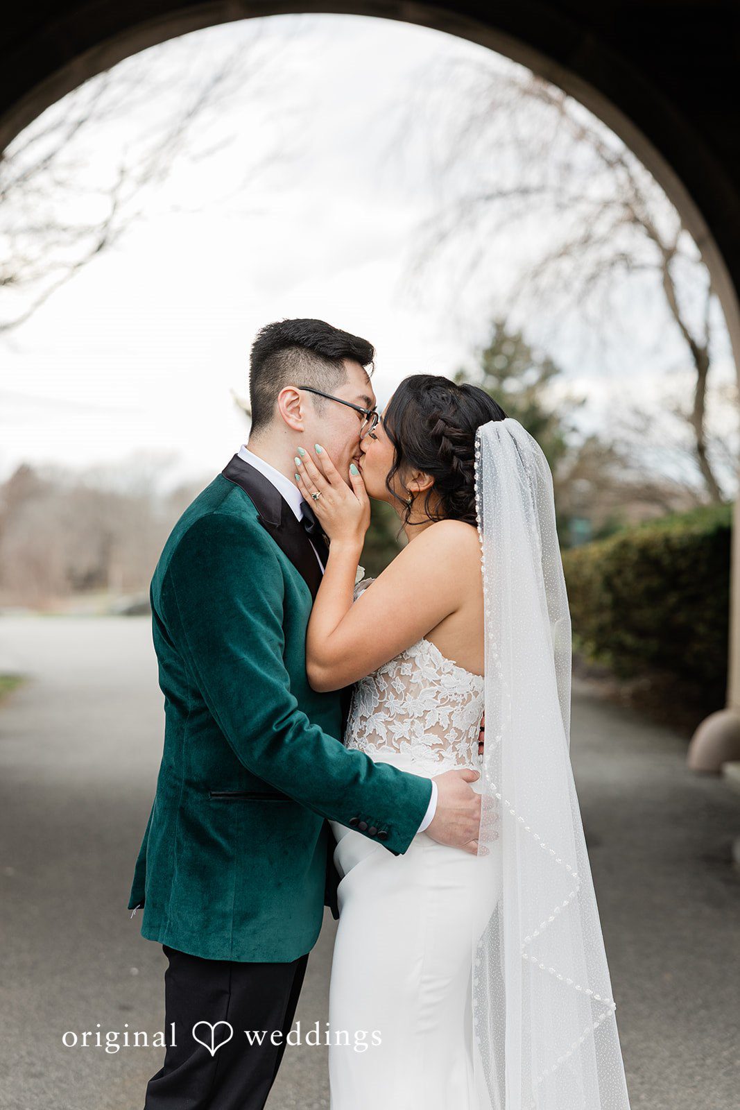 The couple shares a kiss by the stone patio at OceanCliff