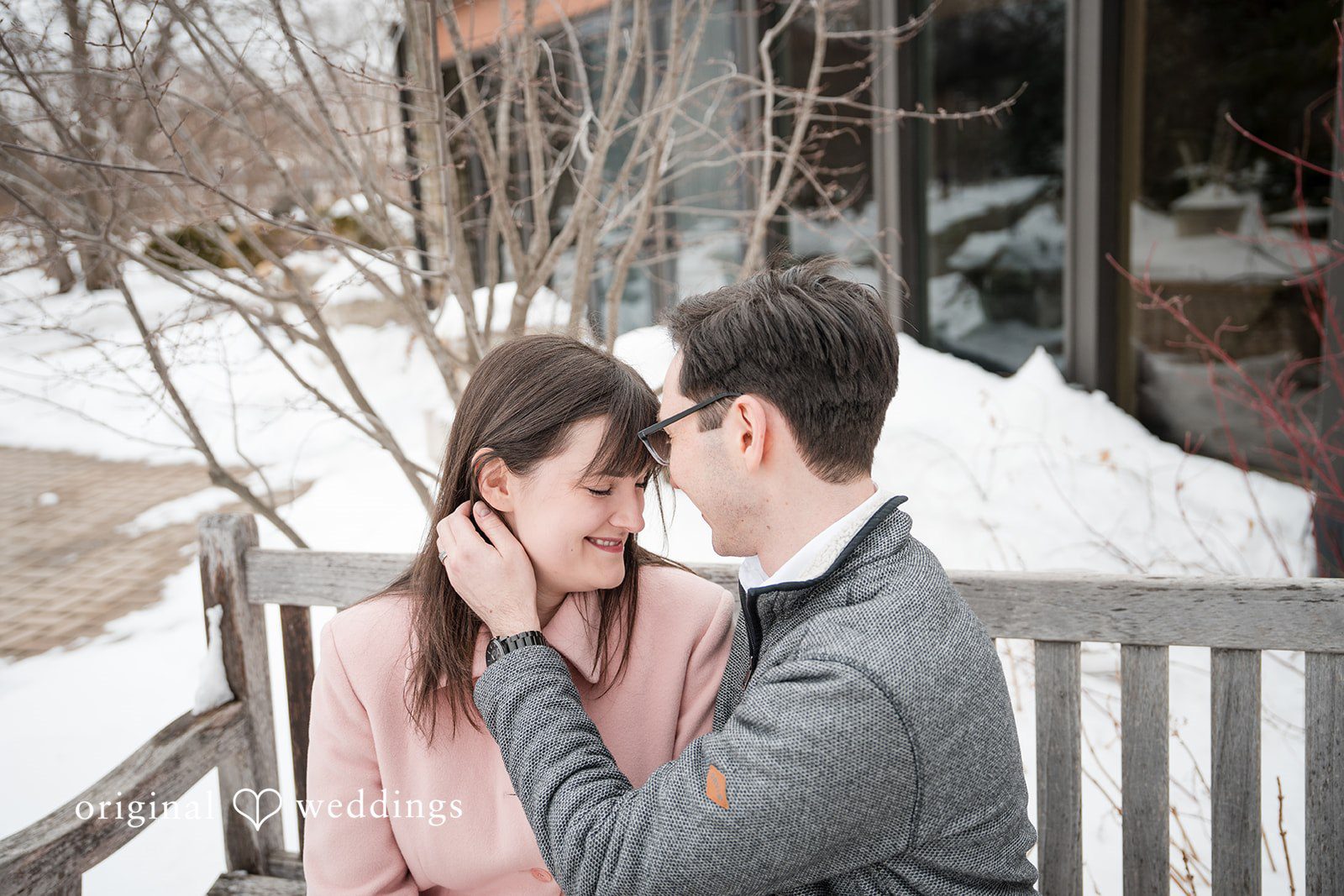 Groom lovingly holds the bride’s face while they share a sweet smile at Olbrich Gardens