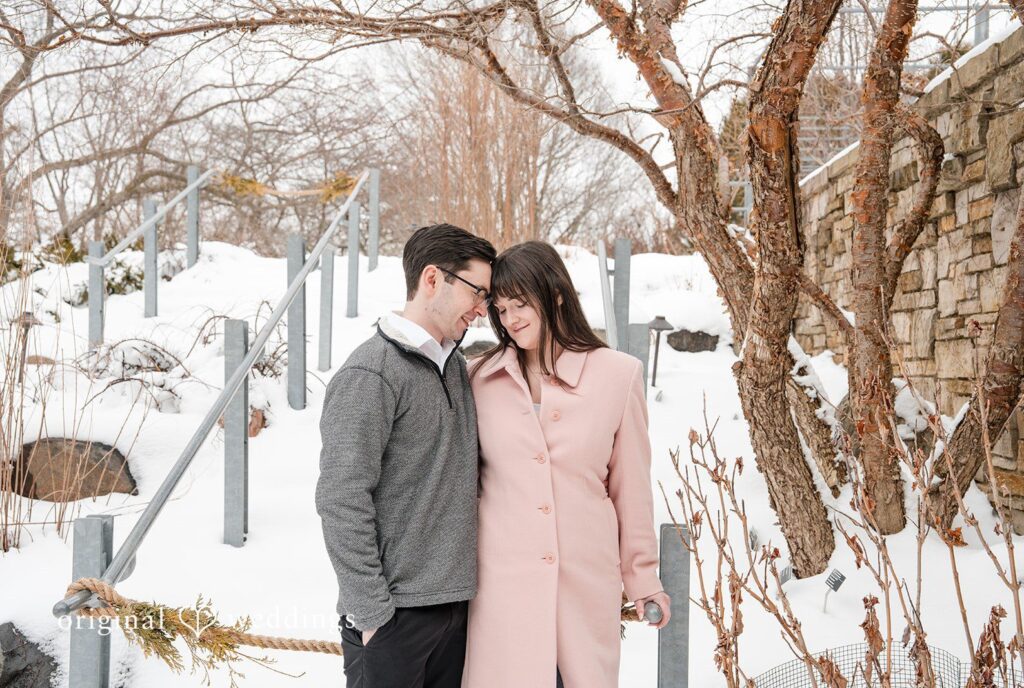 Engagement photography services by Original Weddings, capturing the couple sharing a sweet moment at Olbrich Gardens