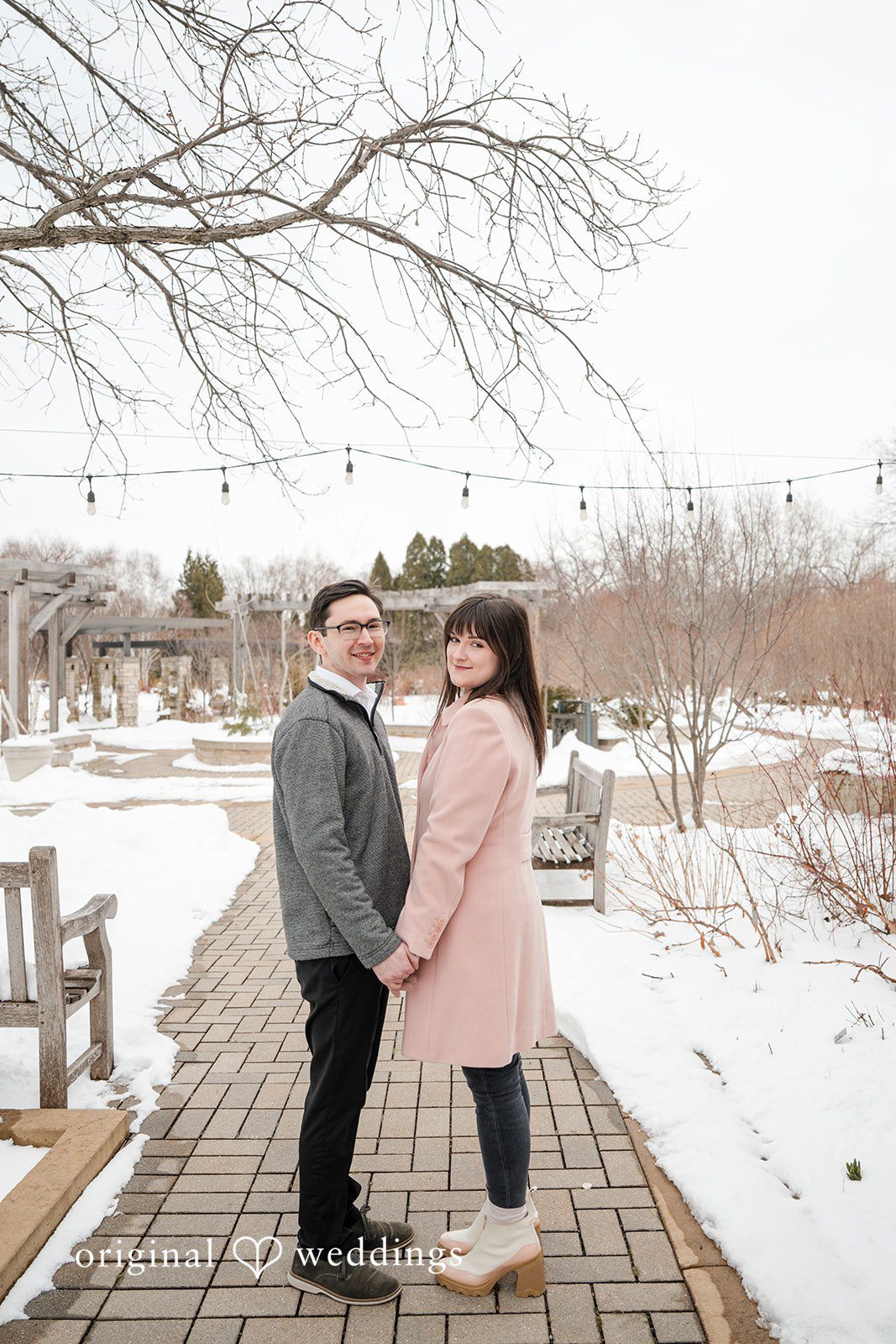 Engagement photography services by Original Weddings capturing a beautiful moment of the couple holding hands at Olbrich Gardens