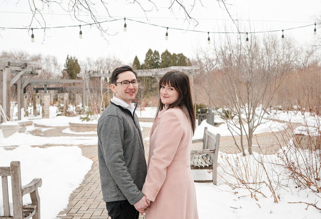 Engagement photography services by Original Weddings capturing a beautiful moment of the couple holding hands at Olbrich Gardens