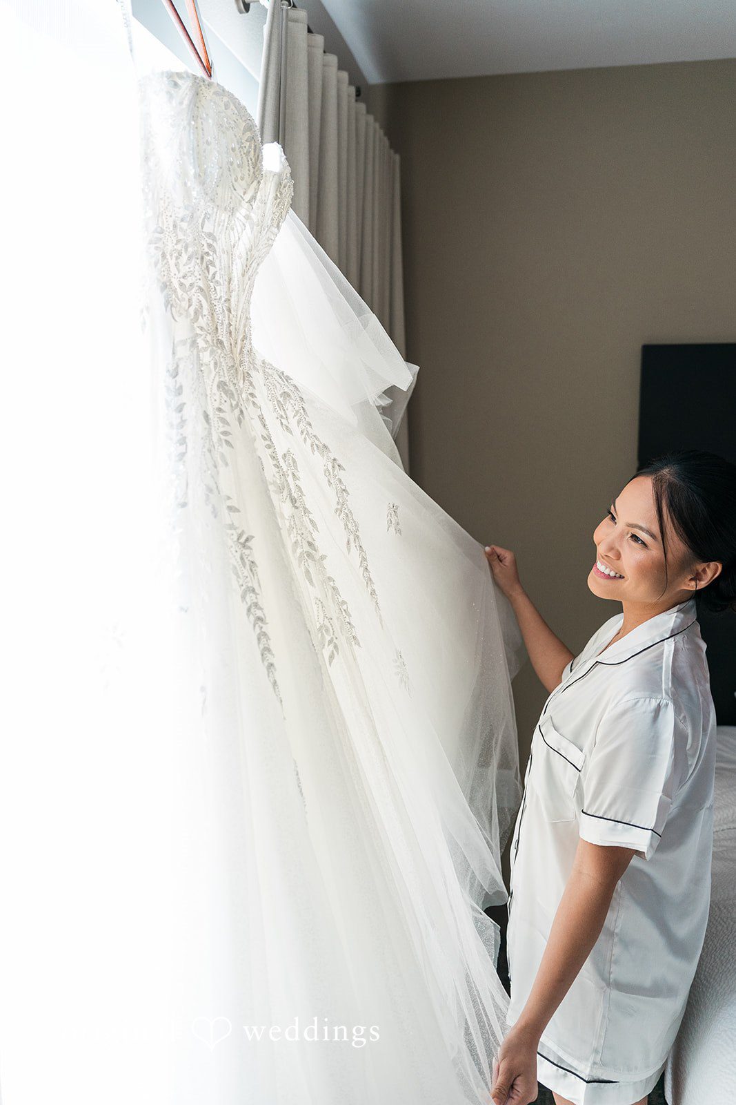 Charize Giann + Mark Shou Bride admiring elegant wedding dress with delicate lace details while getting ready for her wedding