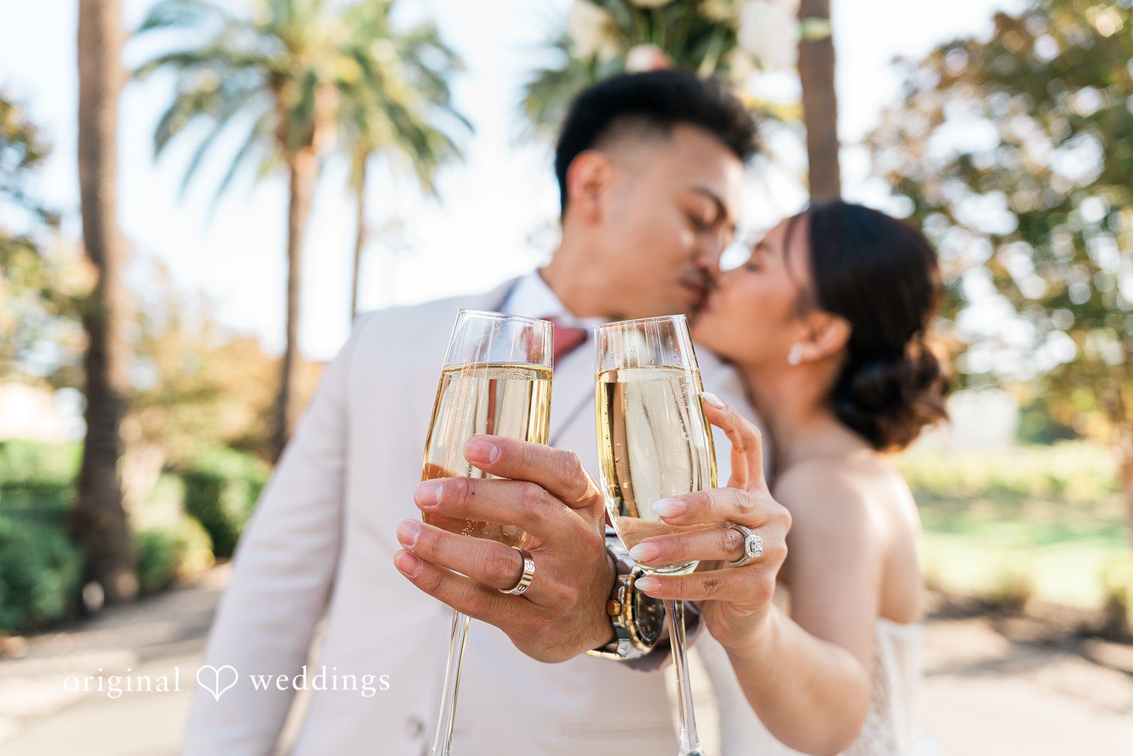 Charize Giann + Mark Shou Bride and groom showing their wedding rings during a champagne toast and romantic kiss at Palm Event Center