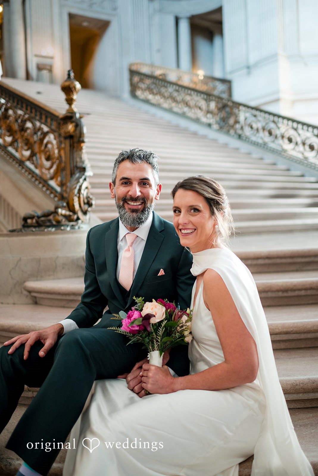 A stunning portrait of the couple framed by the massive stairs of the City Hall