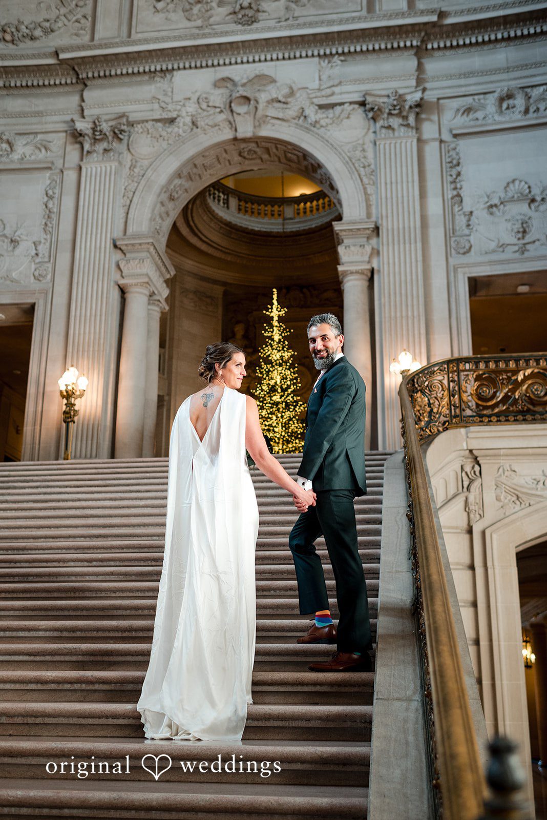 A stylish portrait of the couple by the stairs of the City Hall