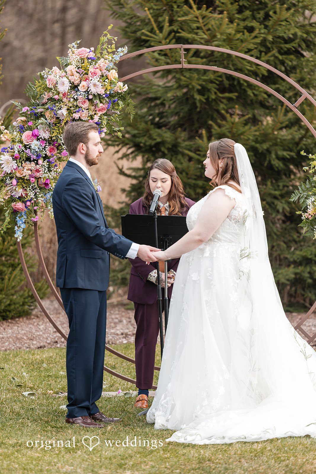 Couple holding hands during wedding ceremony moment at Perona Farms
