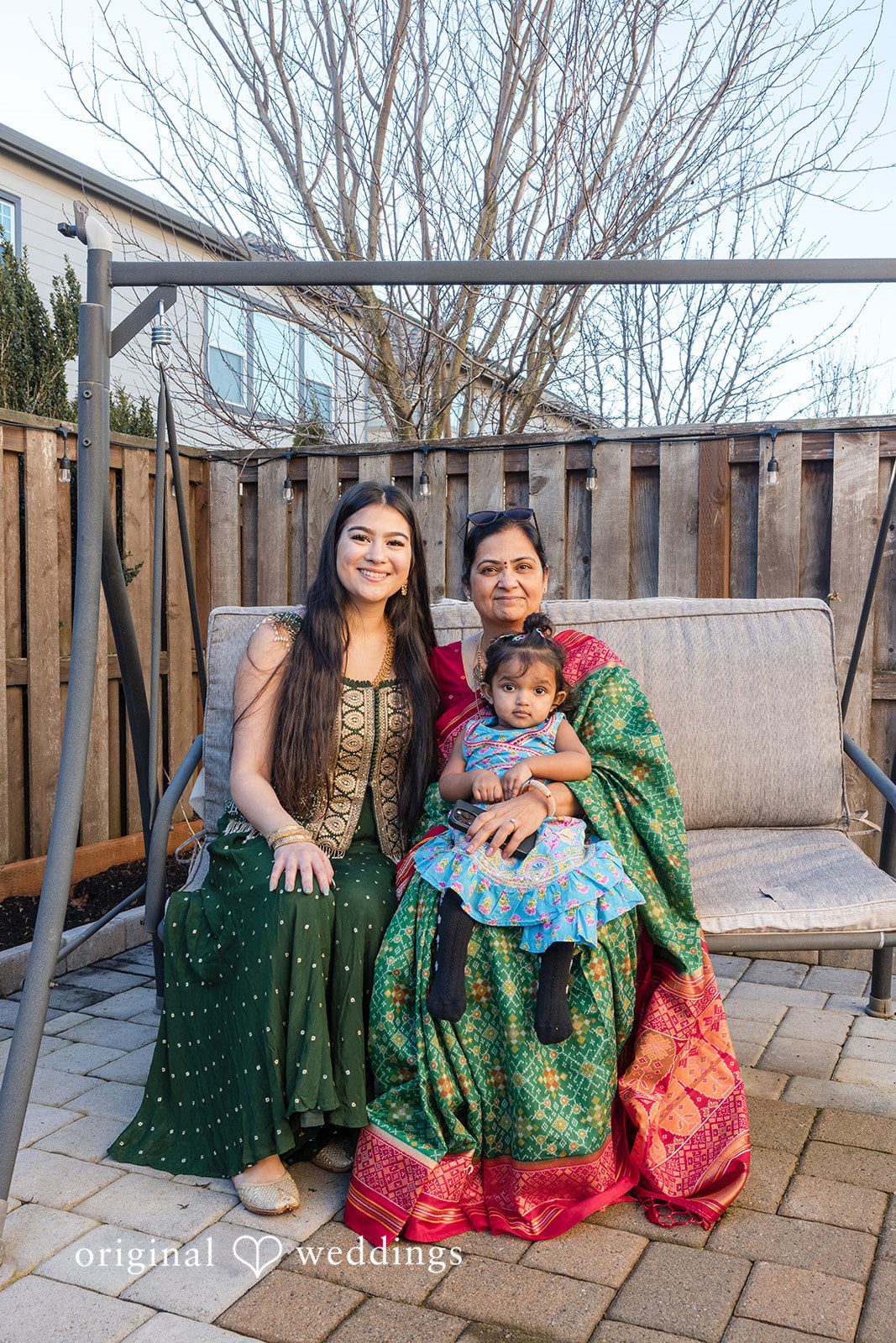 Taylor + Yash Family portrait on outdoor swing captured by Portland Engagement Photographers from Original Weddings