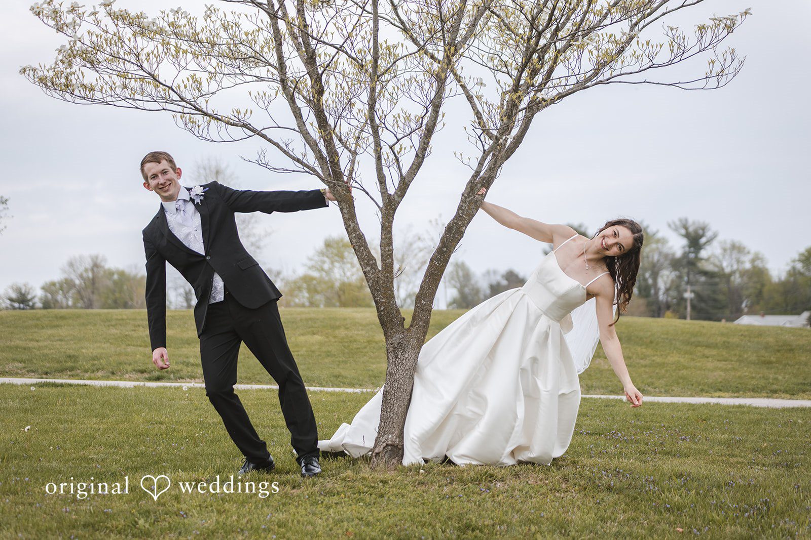 Samantha + Ryan Couple posing together beside a tree during wedding portraits