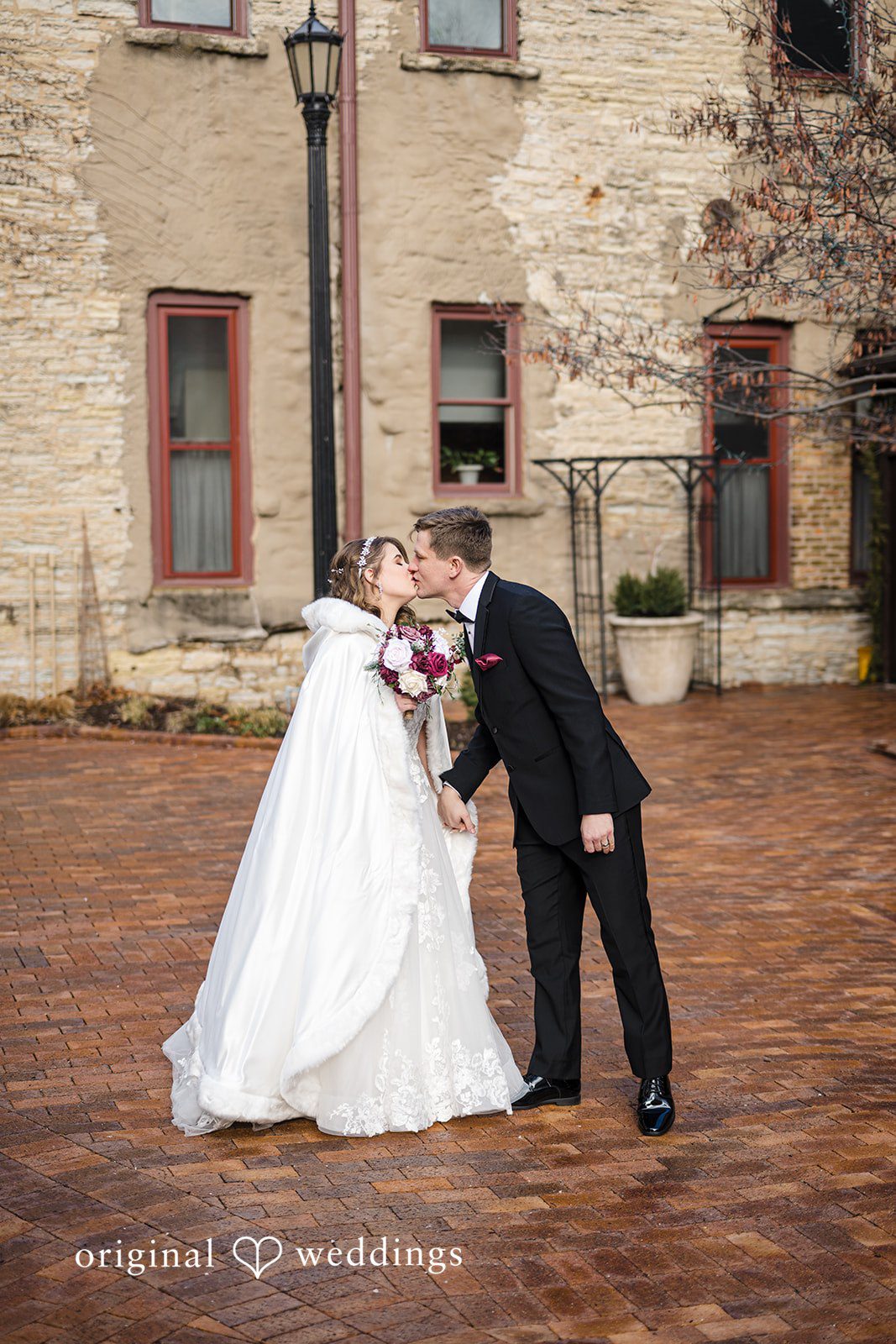 Bride and groom sharing a romantic outdoor kiss