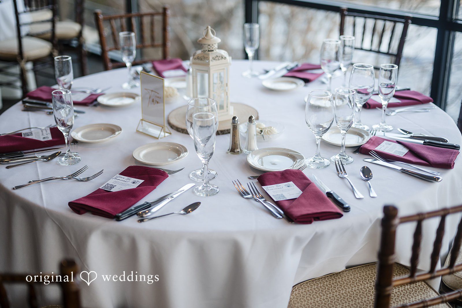 Reception table setup with elegant burgundy napkins and decor