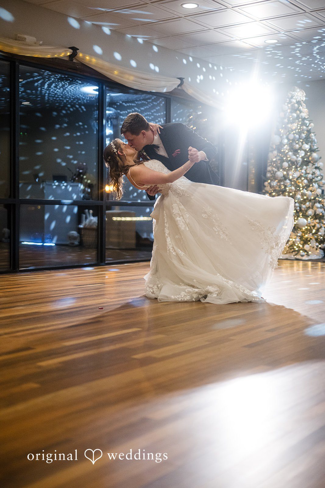 Bride and groom dancing together under reception lights