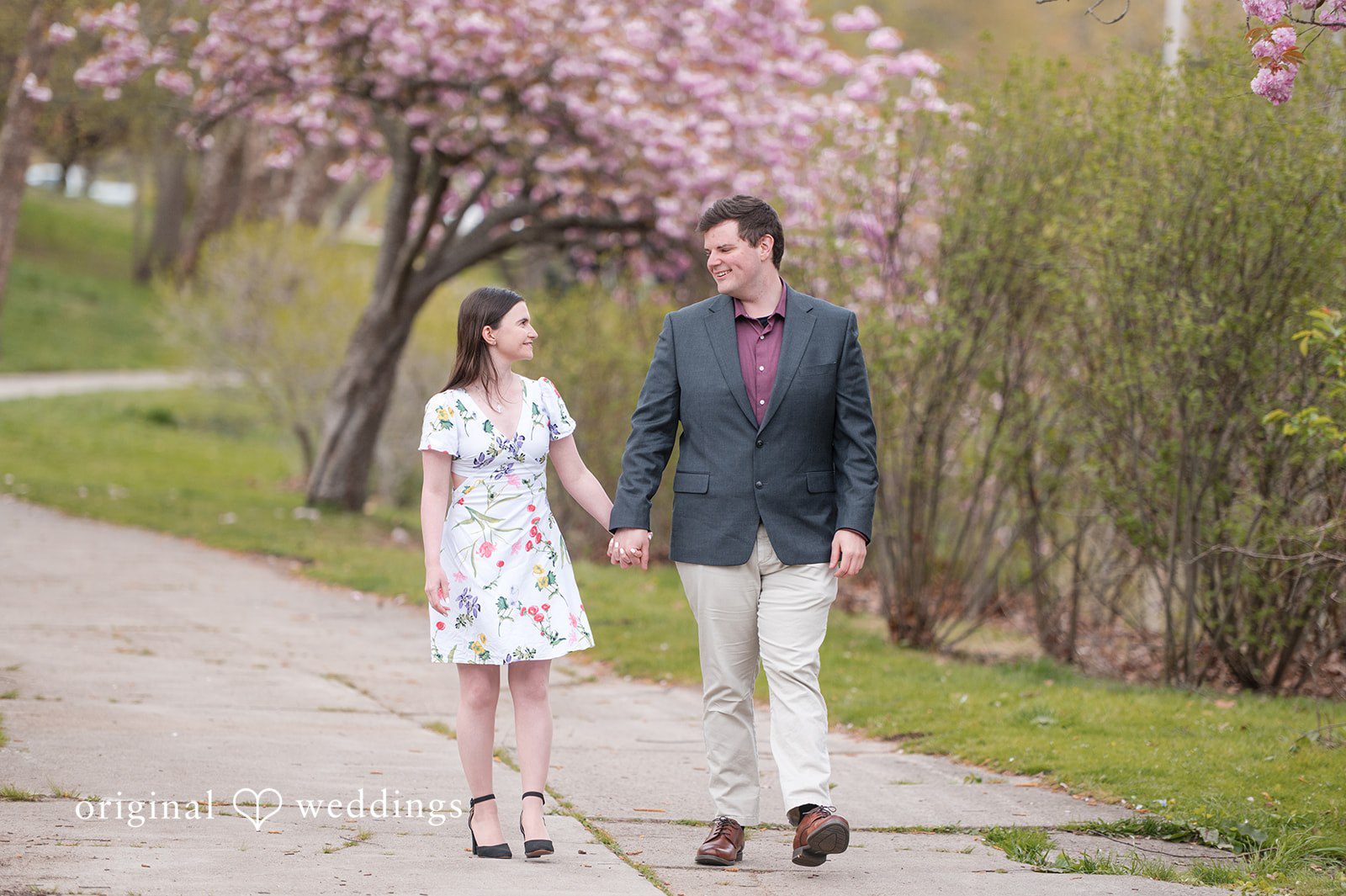 Engagement Photography Services capturing couple walking and looking at each other at Roger Williams Park by Original Weddings