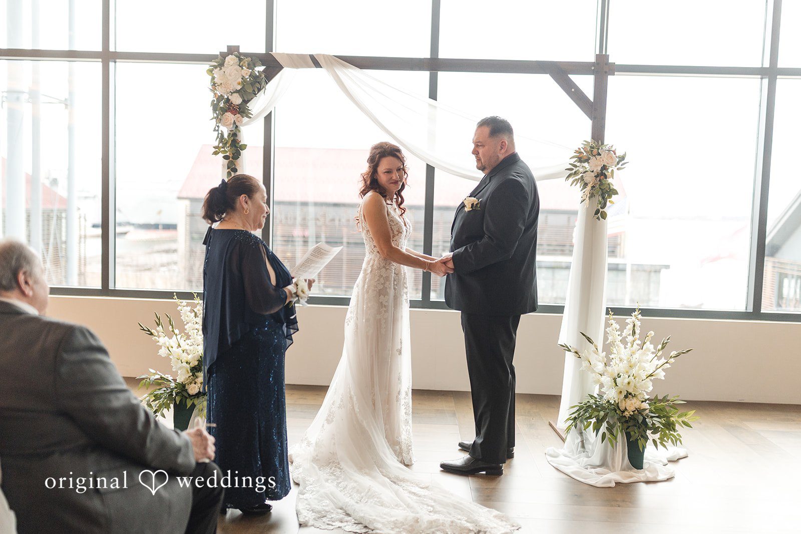Romantic ceremony scene of couple holding hands and listening attentively