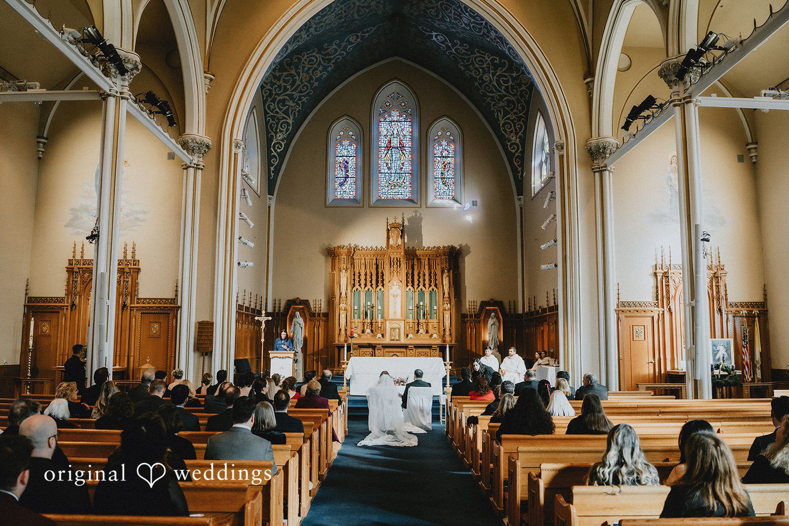 Mary + Ryan Couple seated and listening the priest during ceremony