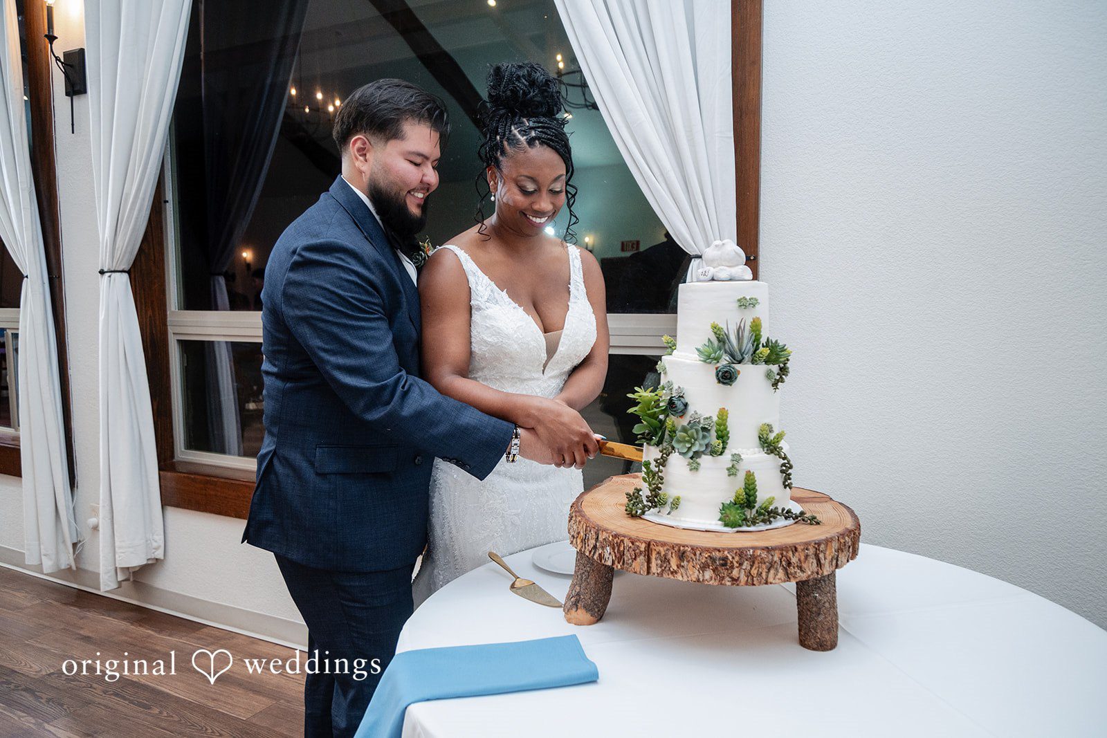 Groom and bride cutting their wedding cake with love
