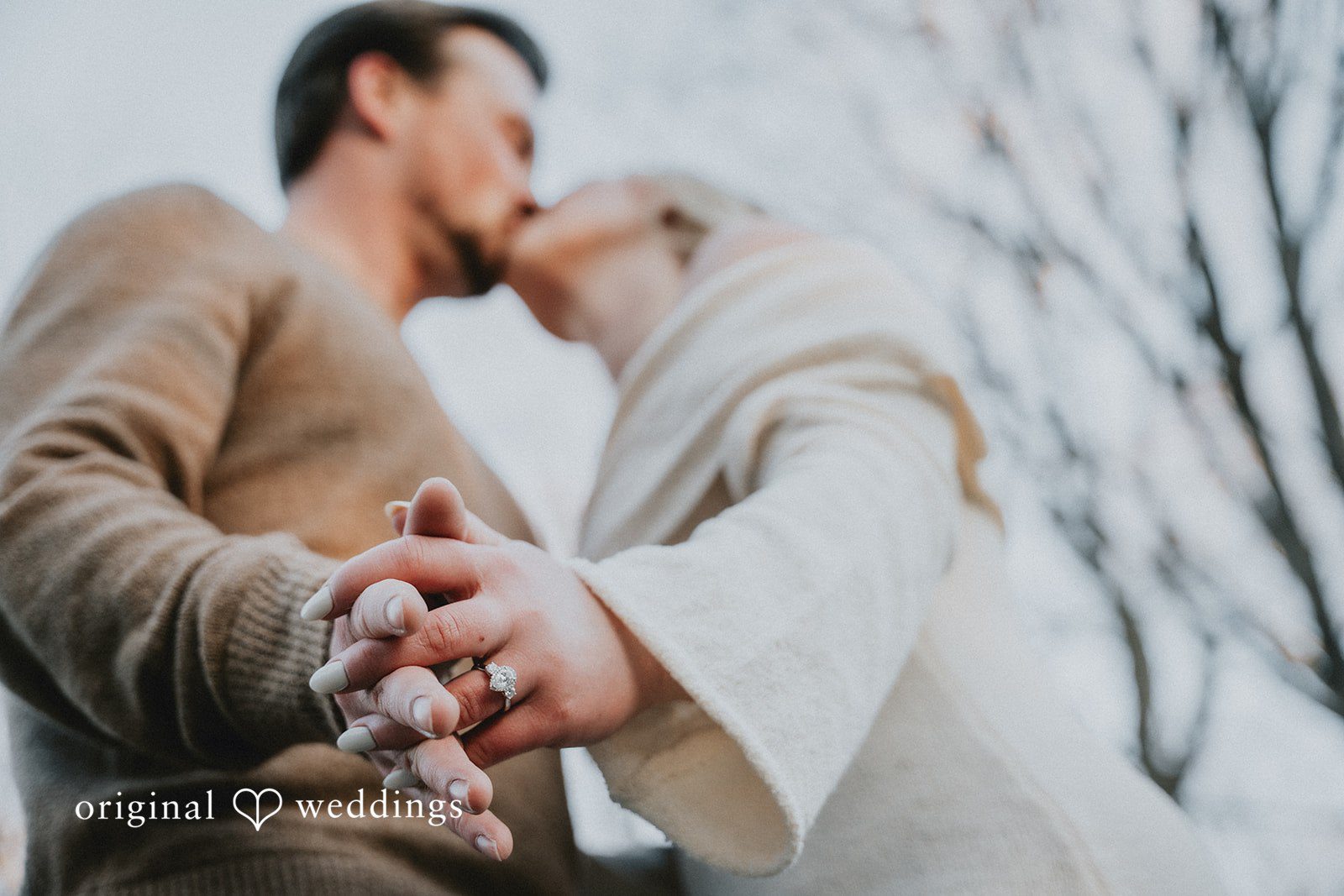 A close-up of a ring while sharing a kiss.