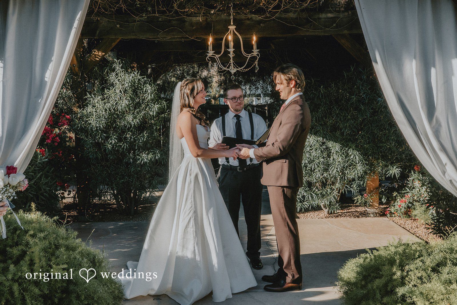 Bride and groom holding hands during wedding ceremony at Shenandoah Mill captured by Phoenix wedding photographers from Original Weddings