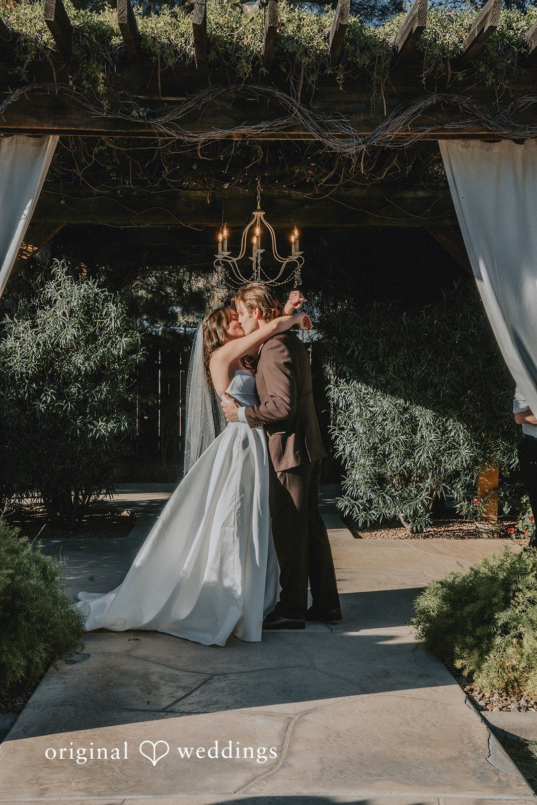Romantic first kiss shared by bride and groom after wedding ceremony at Shenandoah Mill