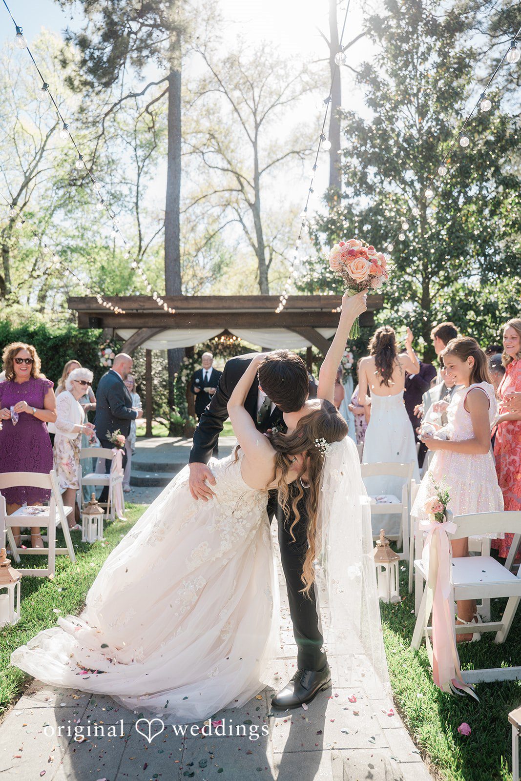 The couple shares a romantic kiss on the aisle