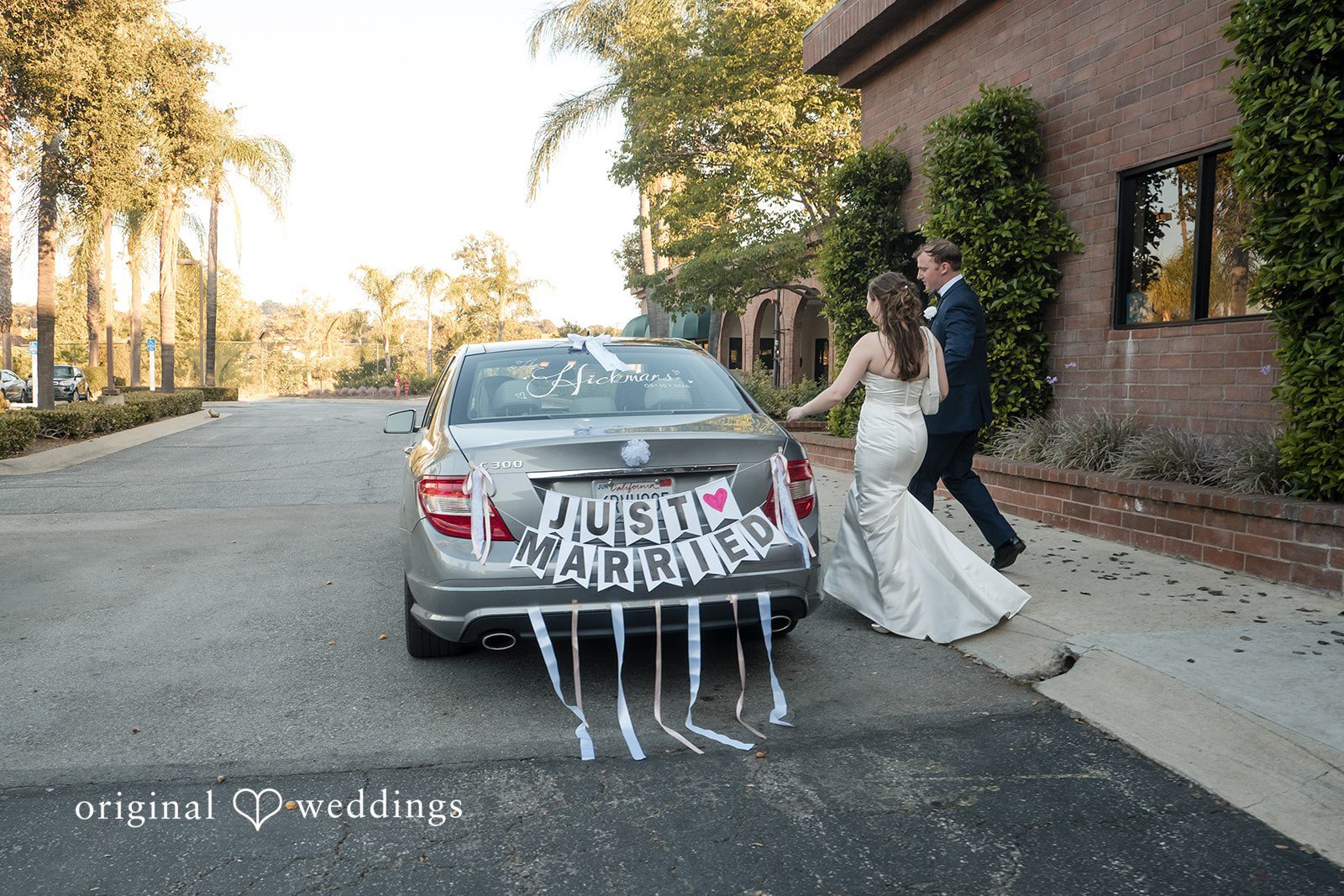 Bride and groom getting into their car after the wedding celebration