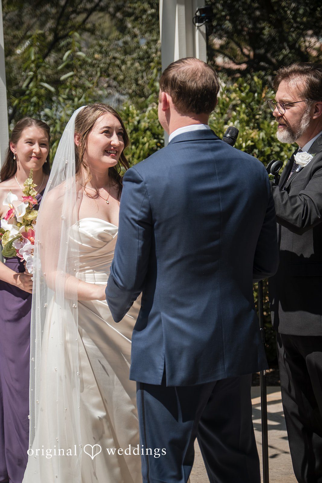 Groom facing away while the bride recites vows during the ceremony