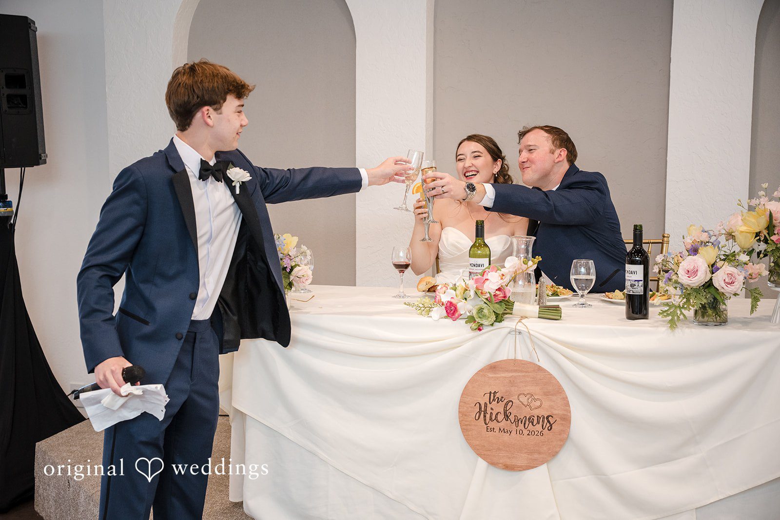 Bride and groom seated together enjoying drinks at the reception