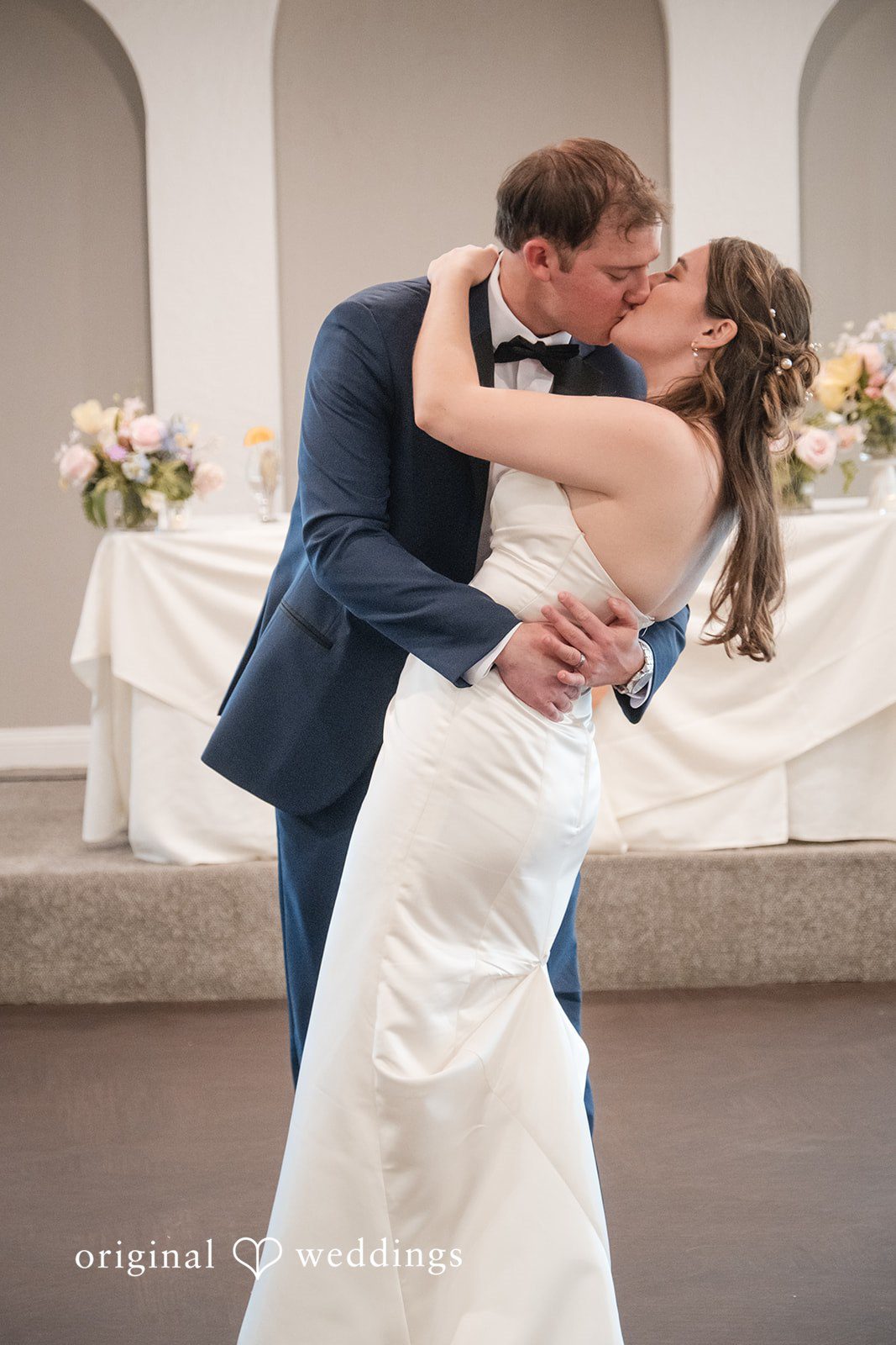 Couple kissing while dancing together during the reception