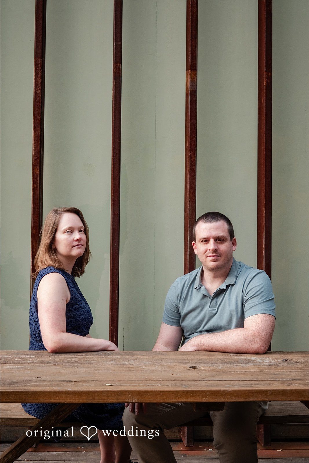 Eric + Kimberly Engaged couple posing together at a wooden table