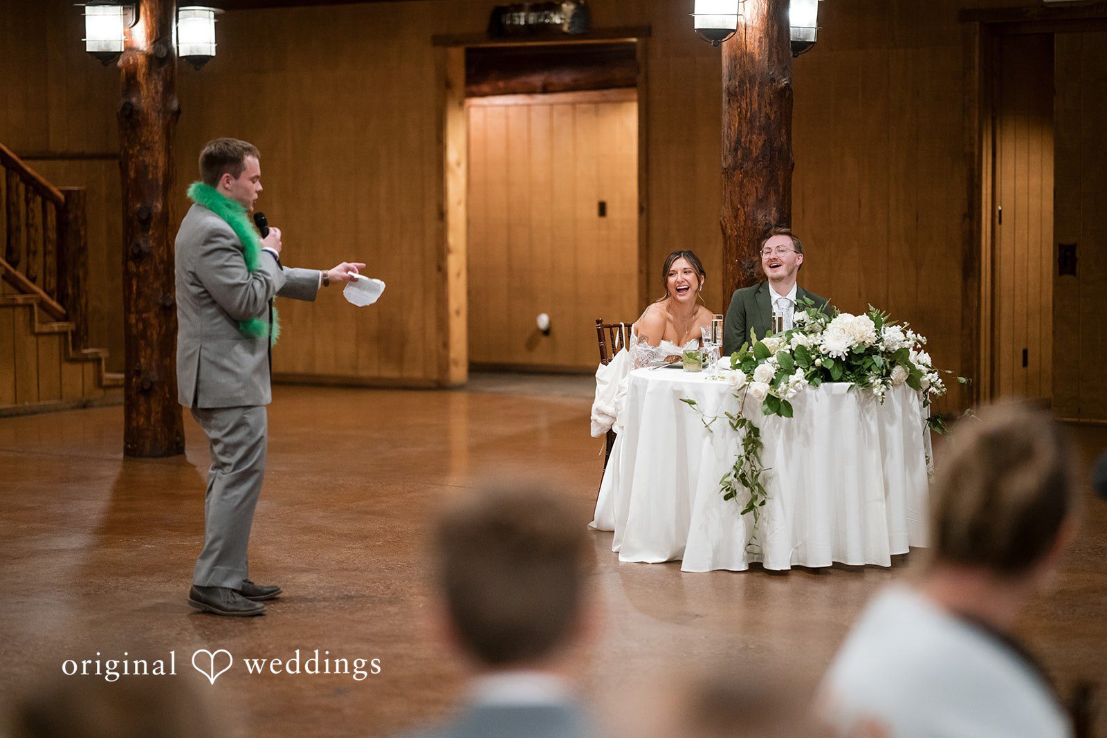Bride and groom seated at their table reading notes from friends