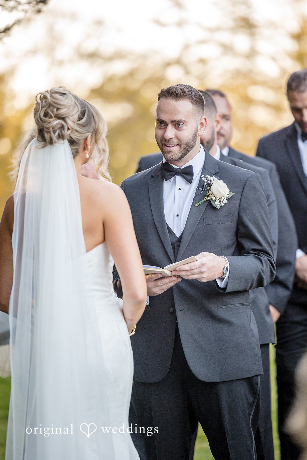 Laura + Nicholas Groom reading a heartfelt note at wedding ceremony with emotional expression