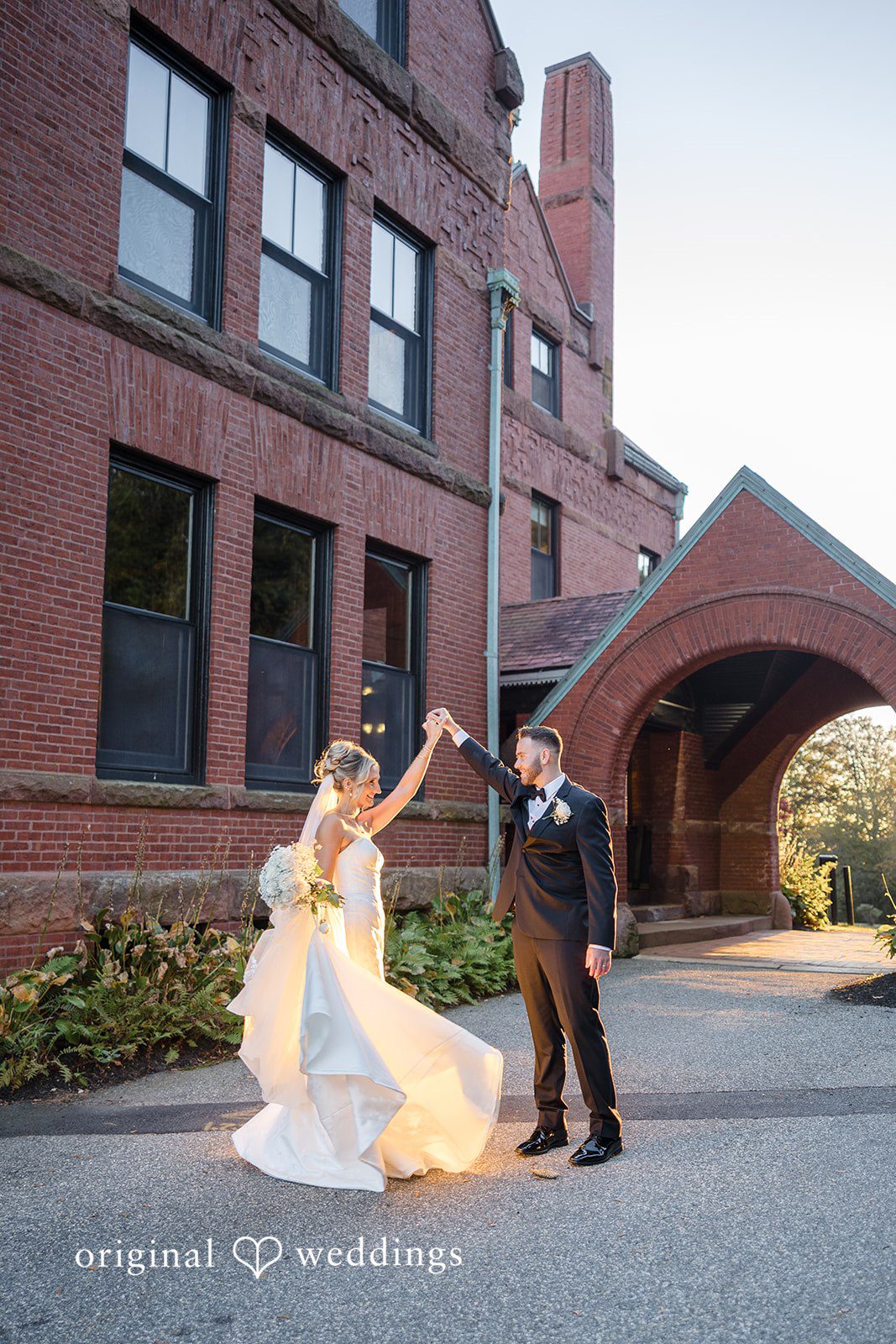 Laura + Nicholas Bride twirling during romantic wedding portrait beside historic estate building