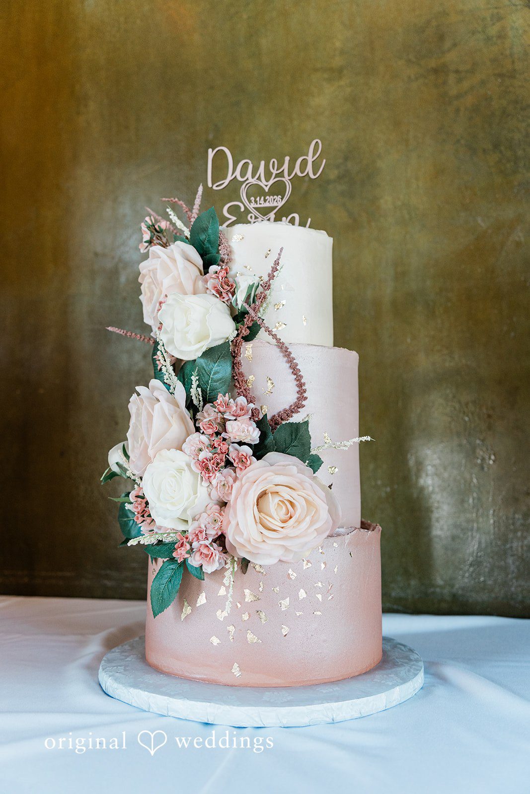 The stunning 3-teir wedding cake adorned with blooms