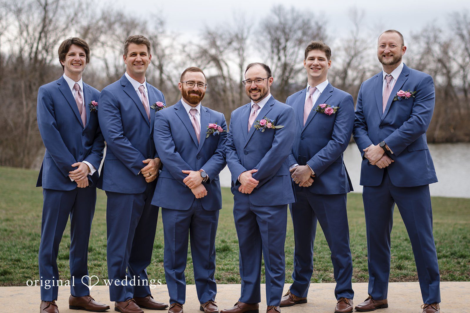Katrena + Ryan Groom posing with groomsmen outside the venue
