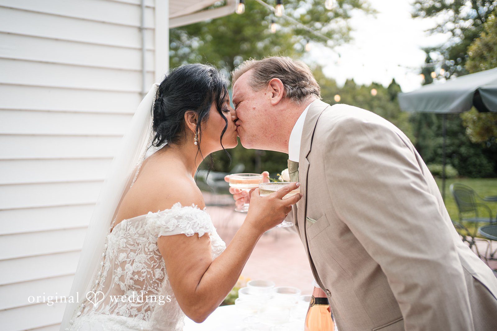 Baltimore Wedding Photographers capturing couple kissing during reception celebration at Swan Harbor Farm by Original Weddings